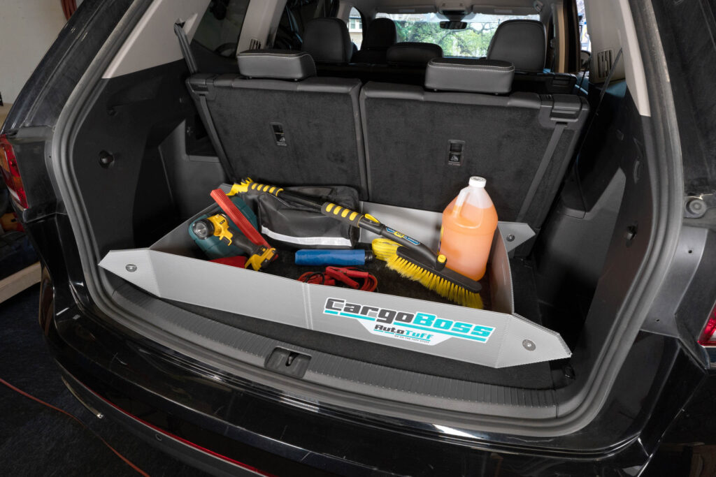 The Cargoboss Snap open storage containing car supplies and tools in an organized manner in the trunk of an SUV.