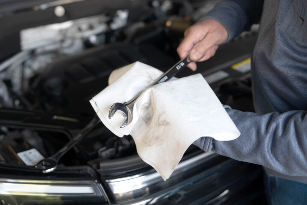 The ragboss rewashable towels being used to wipe of a dirty wrench.