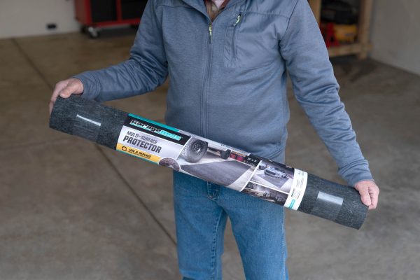 A man holding the Multi-surface protector to show the packaging and scale of product.