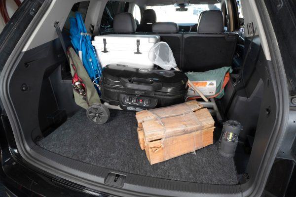 A variety of camping equipment in the trunk of an SUV sitting on the Cargo Liner keeping the trunk protected.
