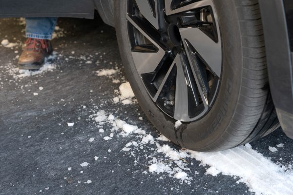 The Garageboss multi-surface protector with packed up snow from a car parked on it containing the mess of snow, road salt, and debris.