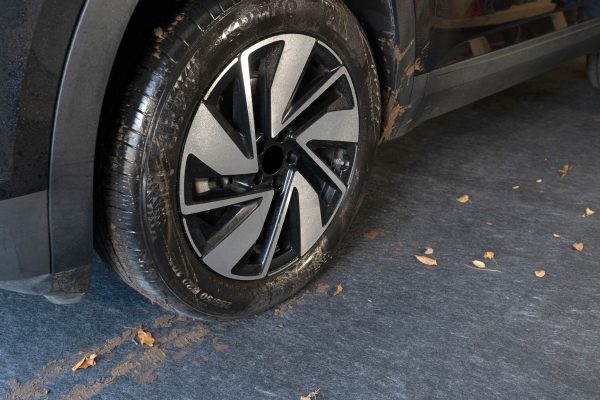 The Garageboss multi-surface protector with an SUV with muddy wheels containing the mess of mud, water, and debris.