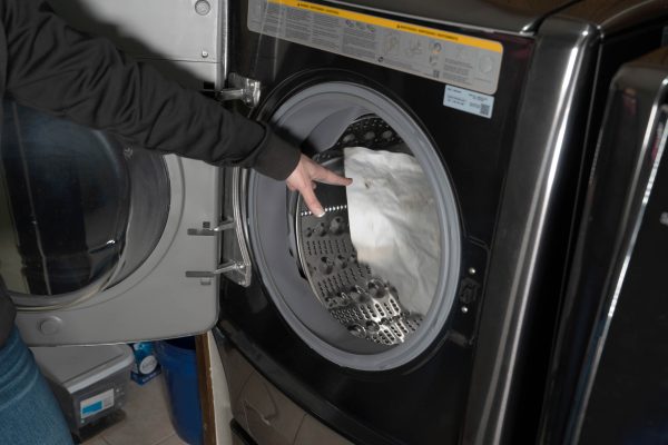 A dirty Ragboss washable rag being thrown in a washer to show washable capability.