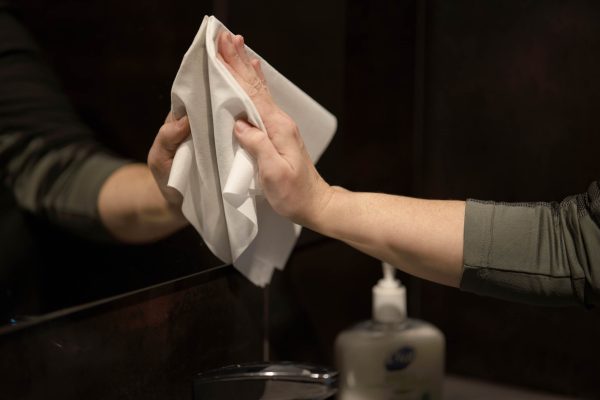 A Ragboss washable rag cleaning a bathroom mirror.