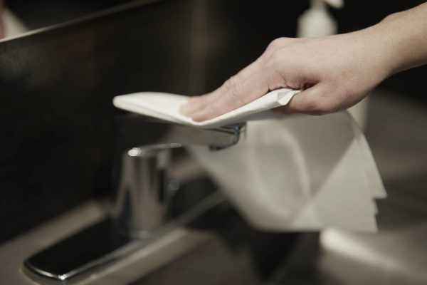 A Ragboss washable rag cleaning a bathroom faucet.