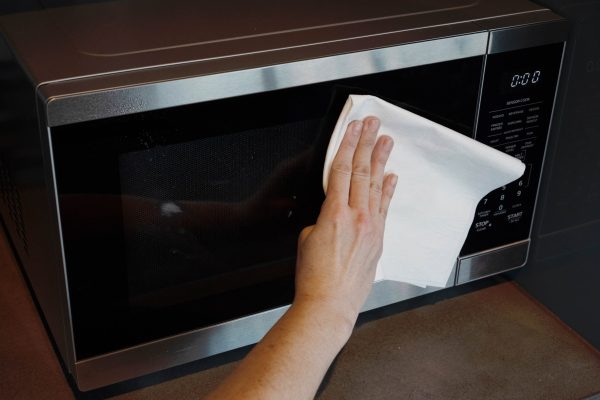 A Ragboss washable rag cleaning a microwave.